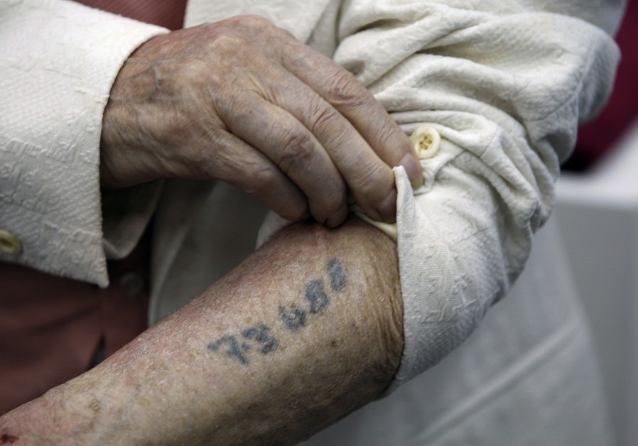 Polish-born Holocaust survivor Meyer Hack shows his prisoner number tattooed on his arm during a news conference at the Yad Vashem Holocaust Museum in Jerusalem June 15, 2009..jpg